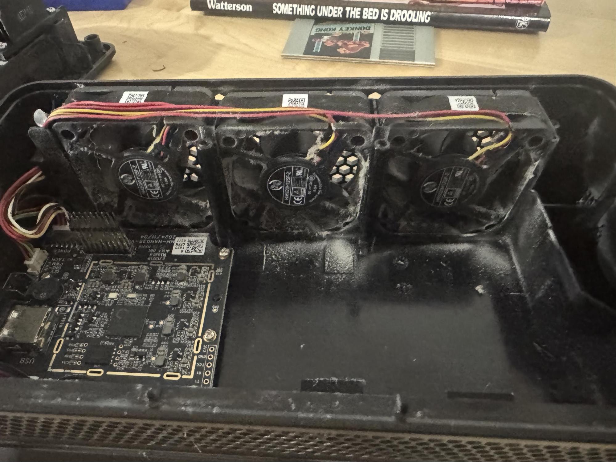 Three 40mm fans with significant dust buildup on blades and housing corners.